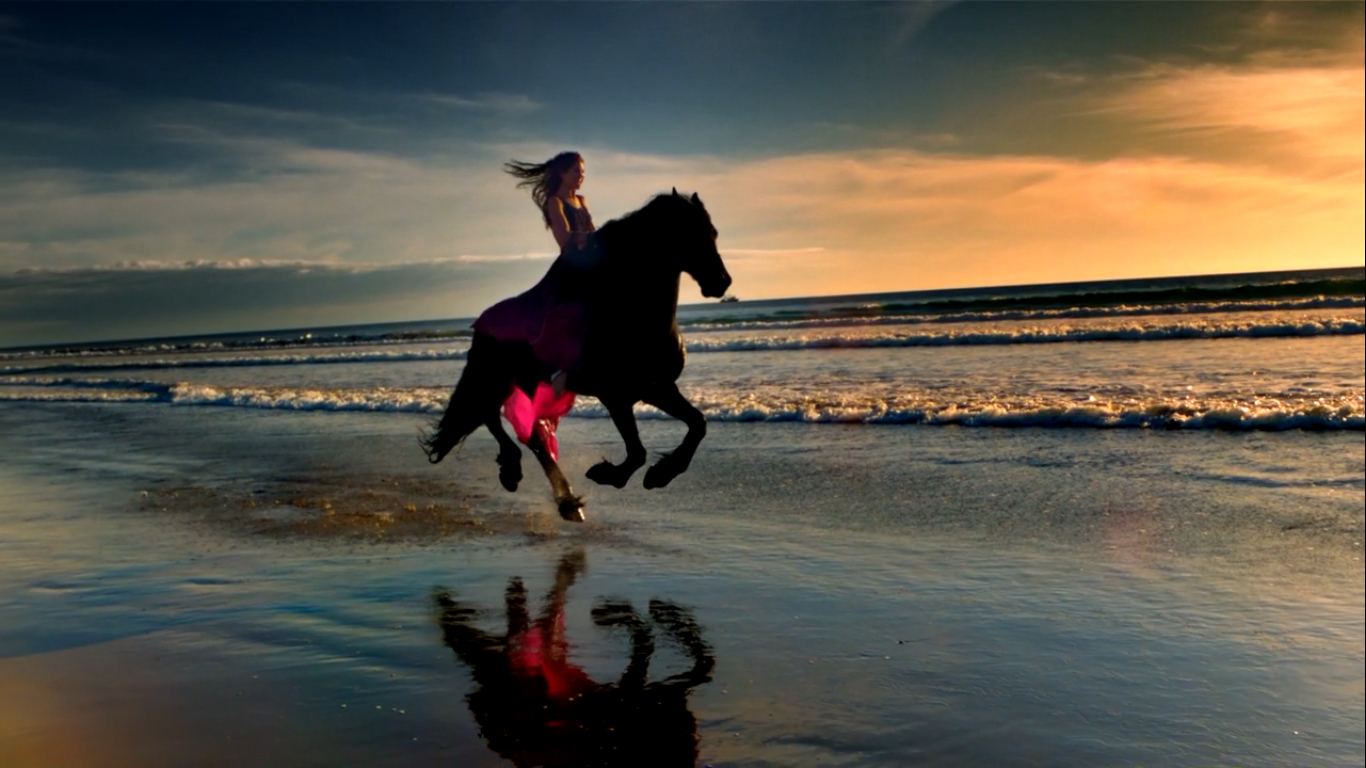 Девушка скачет на коне по берегу моря